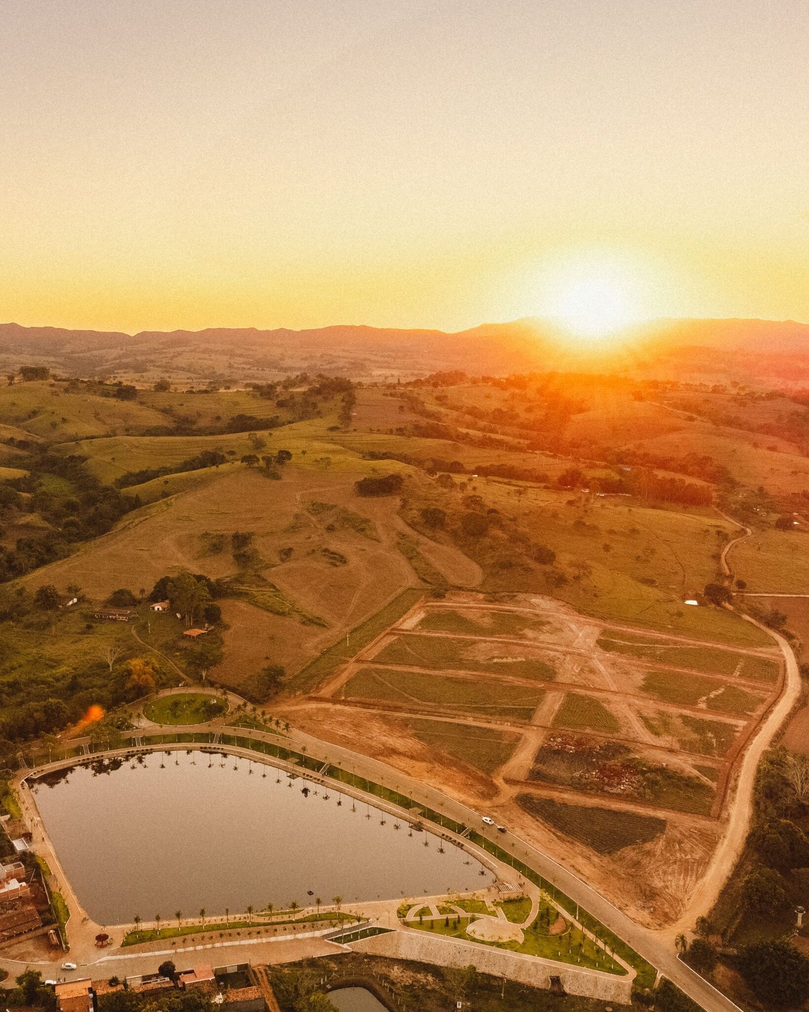 Beautiful aerial image capturing a scenic sunrise over a park reservoir and surrounding landscape.